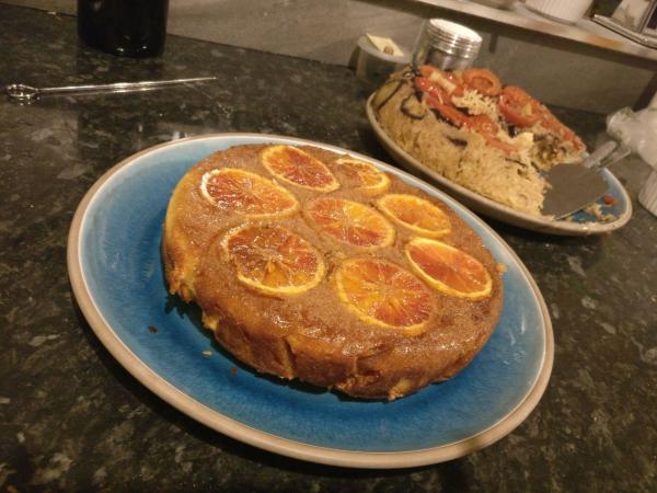 orange, almond & ricotta cake a golden brown cake topped with blood orange slices sits on a blue glazed plate